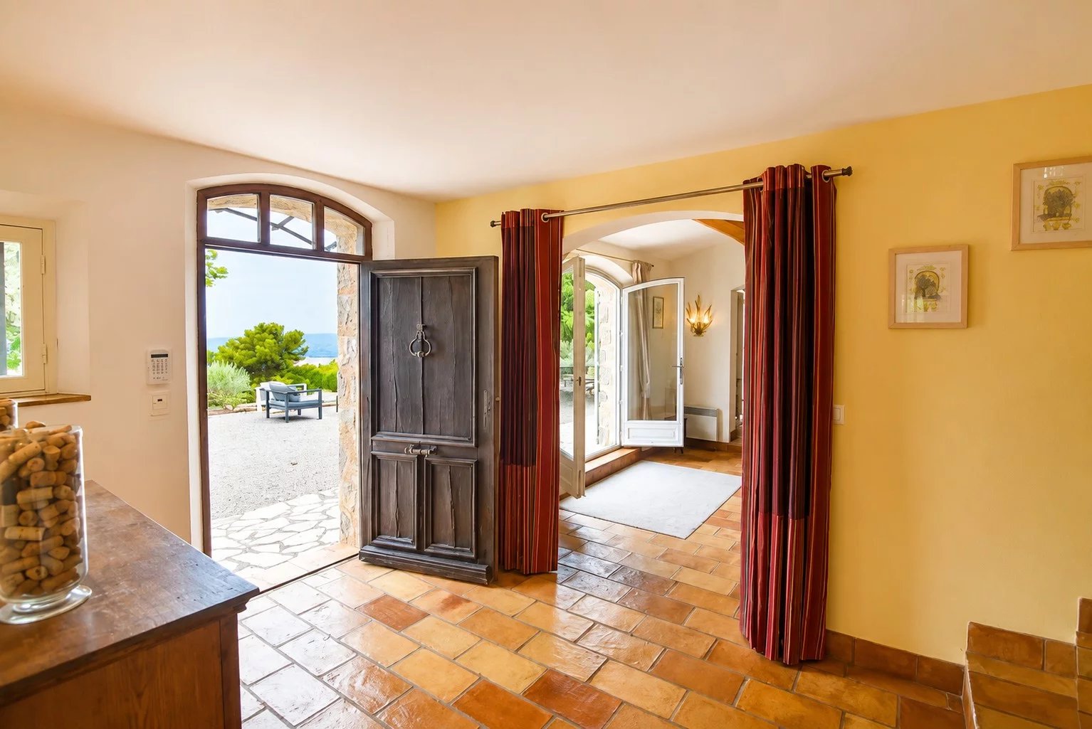 Intérieur d'une maison en pierre avec porte d'entrée en bois et vue sur l'extérieur à Fayence.