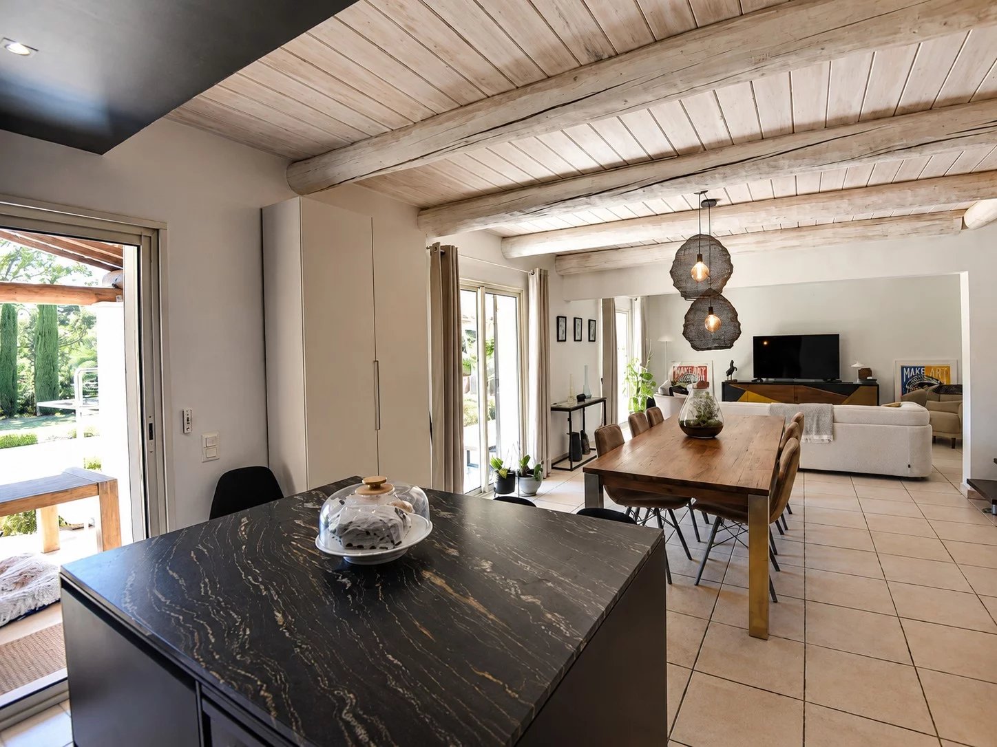 Intérieur d'une villa à Bagnols-en-Forêt avec cuisine ouverte et salle à manger lumineuse.