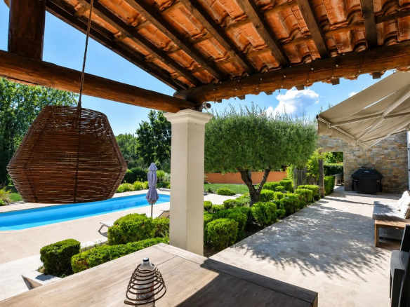 Terrasse avec piscine et jardin dans une villa à Bagnols-en-Forêt.