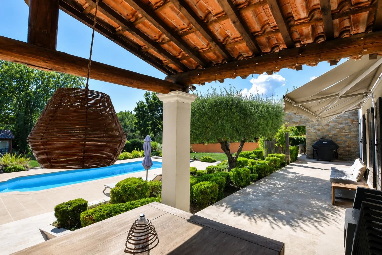 Terrasse avec piscine et jardin dans une villa à Bagnols-en-Forêt.