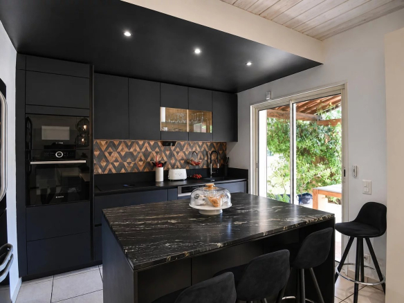 Cuisine moderne avec îlot central et équipements contemporains dans une villa à Bagnols-en-Forêt.