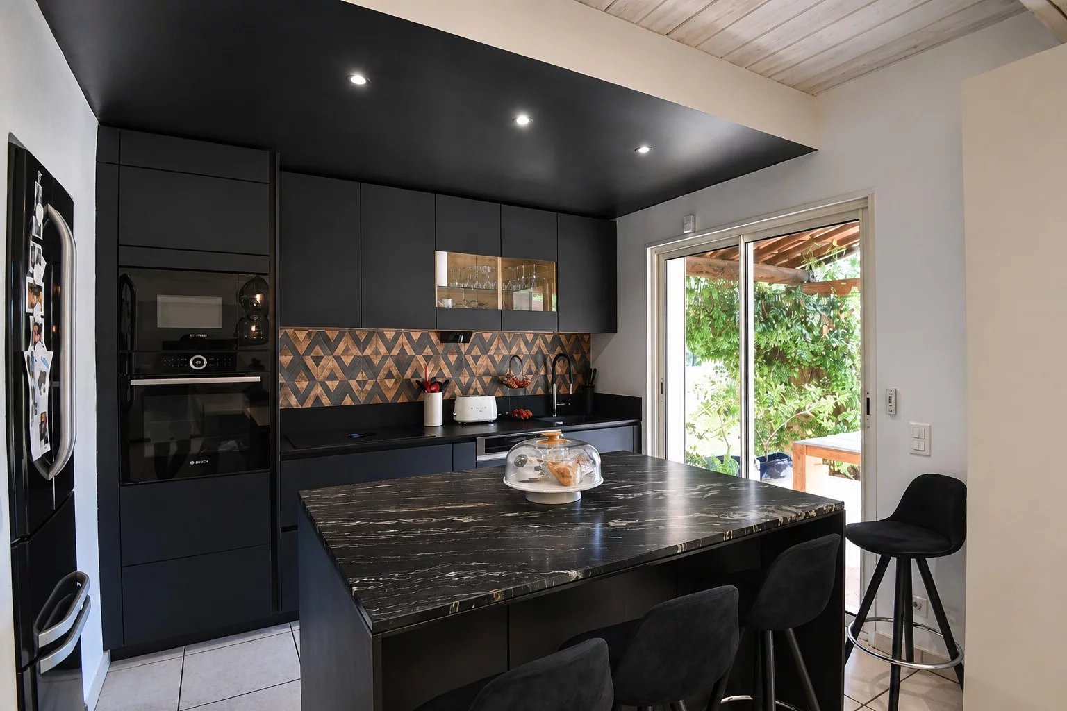 Cuisine moderne avec îlot central et équipements contemporains dans une villa à Bagnols-en-Forêt.