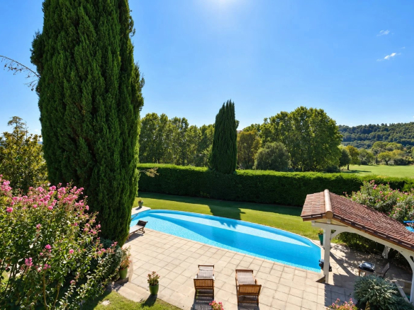 View of an infinity pool surrounded by greenery and flowers in Callian.