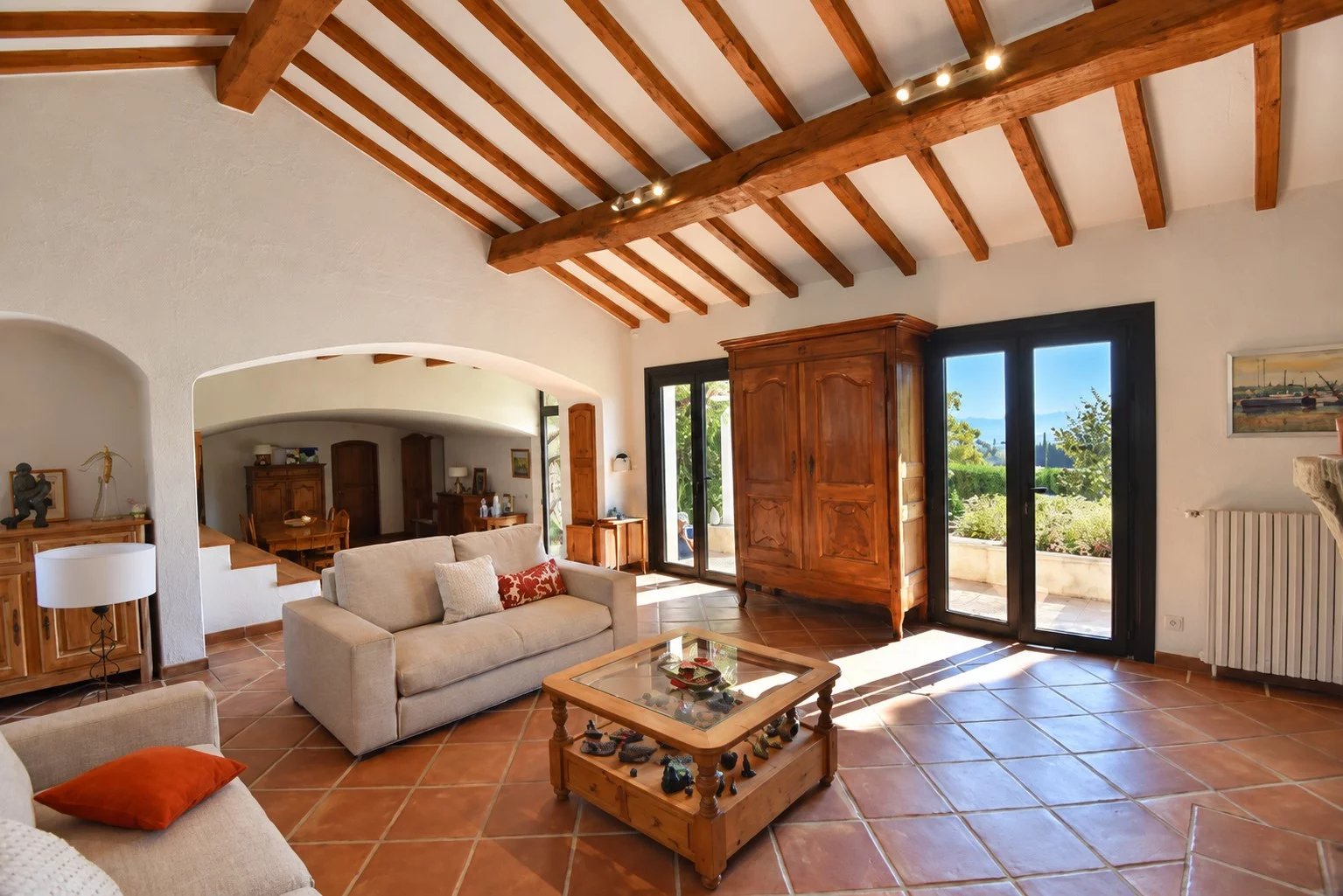 Interior of a Provençal property in Callian Interior of a Provençal property with a bright living room, exposed beams and a view of the garden.