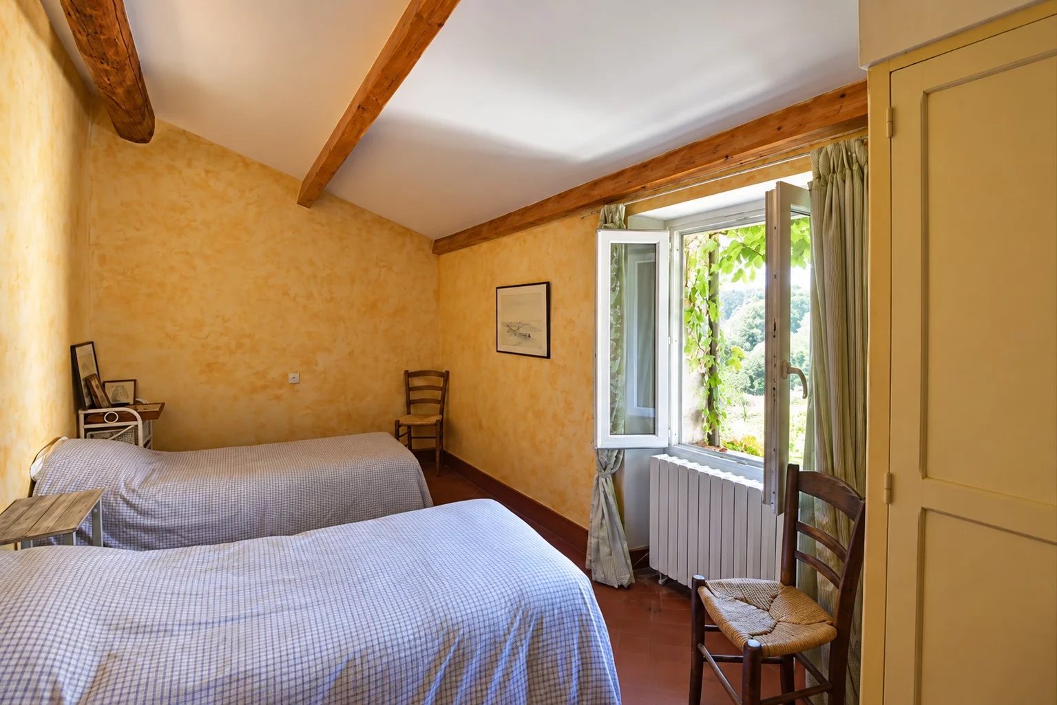 Provencal room in Callian Room with two single beds and a window overlooking a garden in Callian