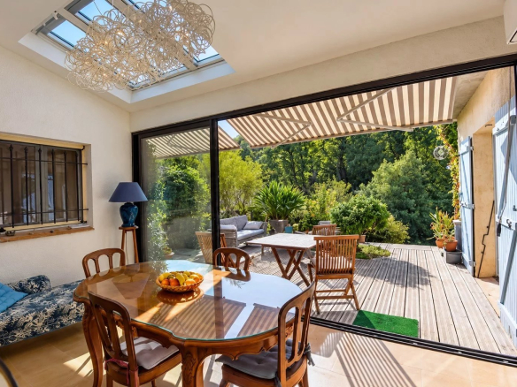 Intérieur d'une villa à Tourrettes avec salle à manger et accès à une terrasse extérieure.