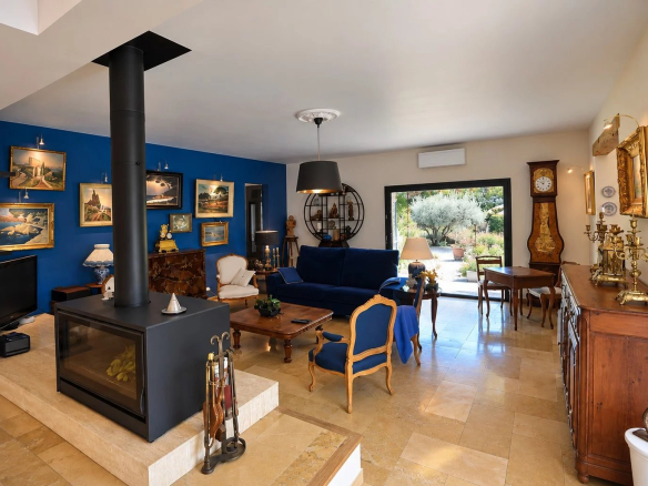 Intérieur d'une villa à Tourrettes avec salon spacieux, cheminée et décoration artistique.