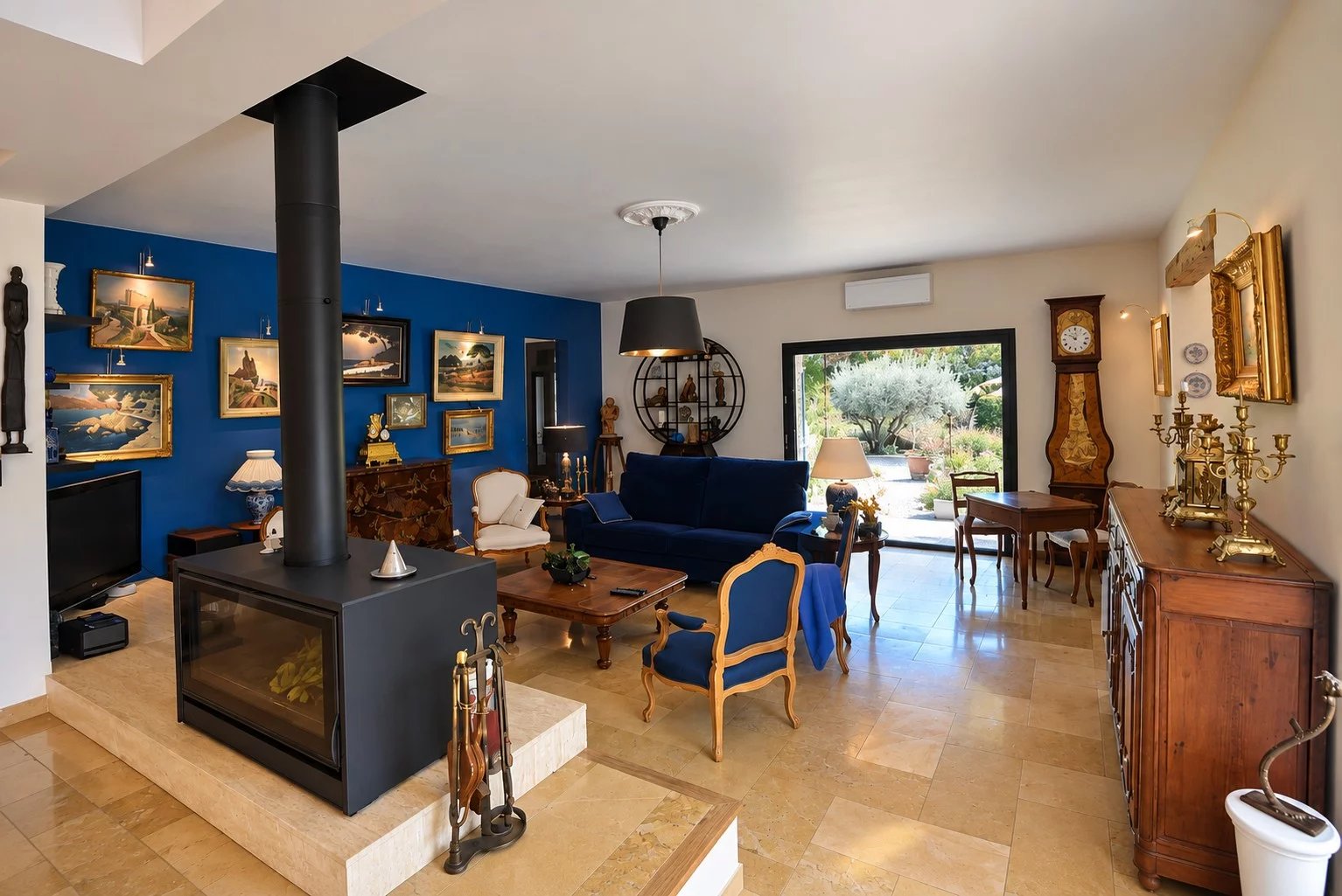 Intérieur d'une villa à Tourrettes avec salon spacieux, cheminée et décoration artistique.