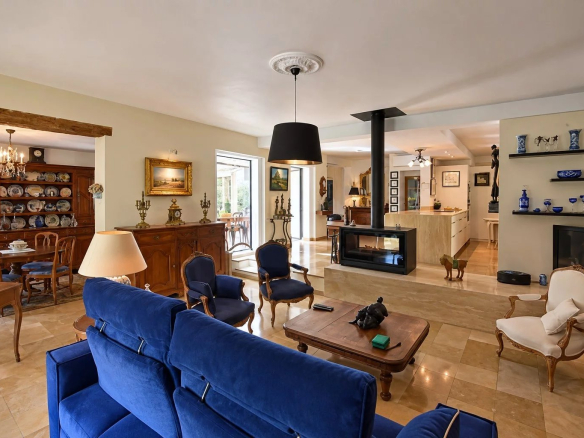 Intérieur d'une villa à Tourrettes avec salon, cheminée et cuisine ouverte.