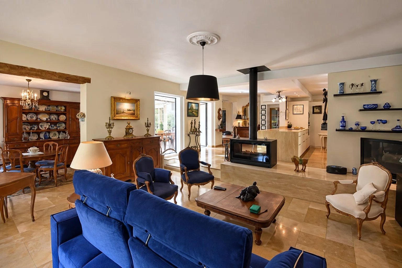 Intérieur d'une villa à Tourrettes avec salon, cheminée et cuisine ouverte.