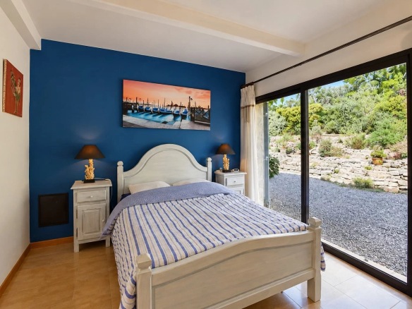 Chambre d'une villa à Tourrettes avec lit double et vue sur le jardin.