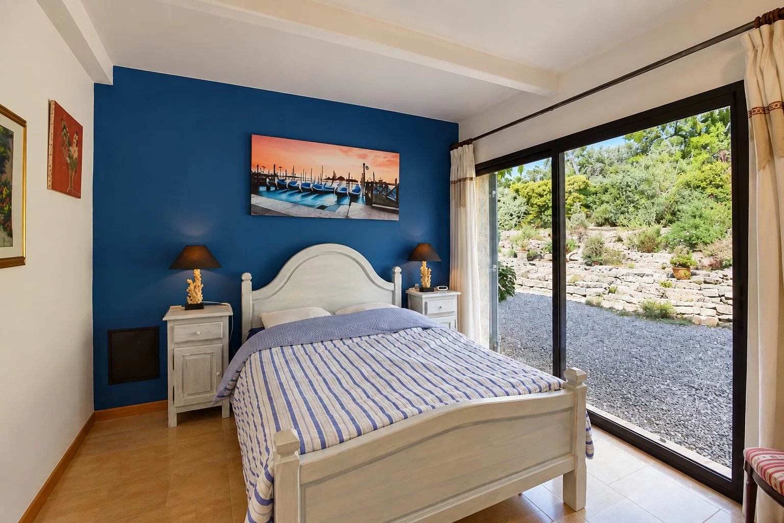 Chambre d'une villa à Tourrettes avec lit double et vue sur le jardin.