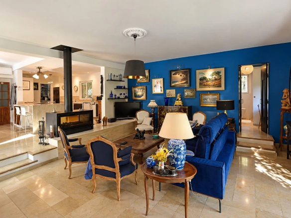 Intérieur d'une villa spacieuse avec salon, cheminée et décor artistique.