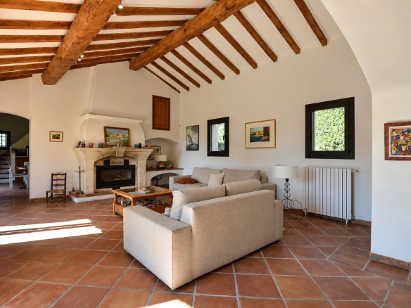 Interior of a property in Callian with a bright living room, exposed beams and a fireplace.