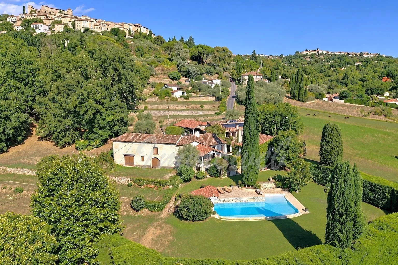 Character property in Callian Aerial view of a property with swimming pool and green grounds in Callian, surrounded by nature.