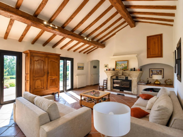 Interior of a property in Callian with a bright living room, exposed beams and a fireplace.