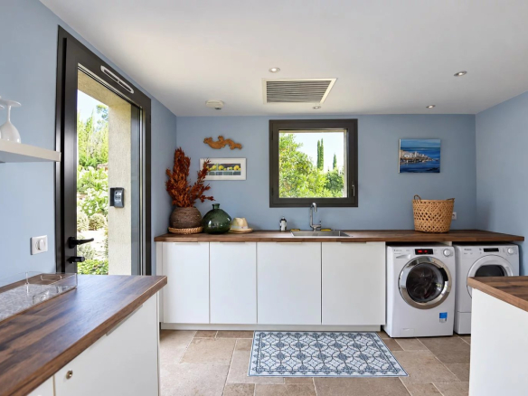 Interior of a modern laundry room with appliances and access to the outside.