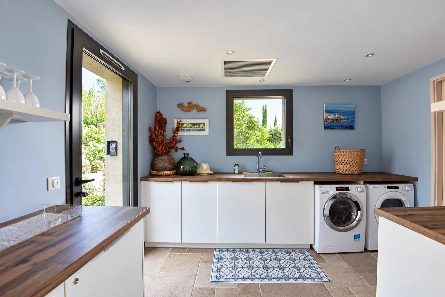 Modern laundry room in a luxury villa Interior of a modern laundry room with appliances and access to the outside.