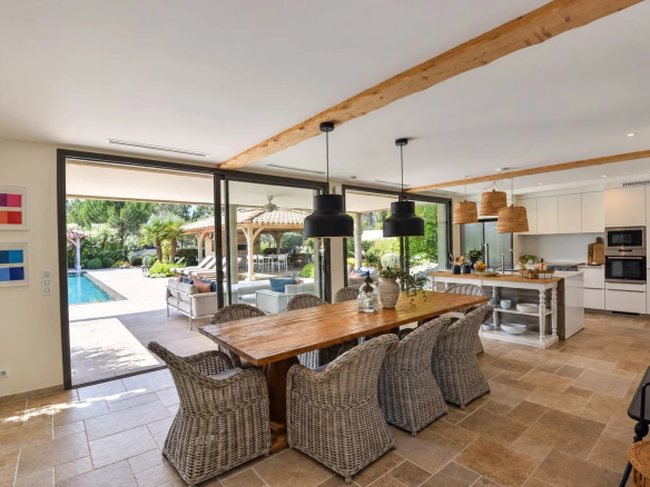 Interior of a contemporary villa with dining room and view of the outdoor pool in Tourrettes.
