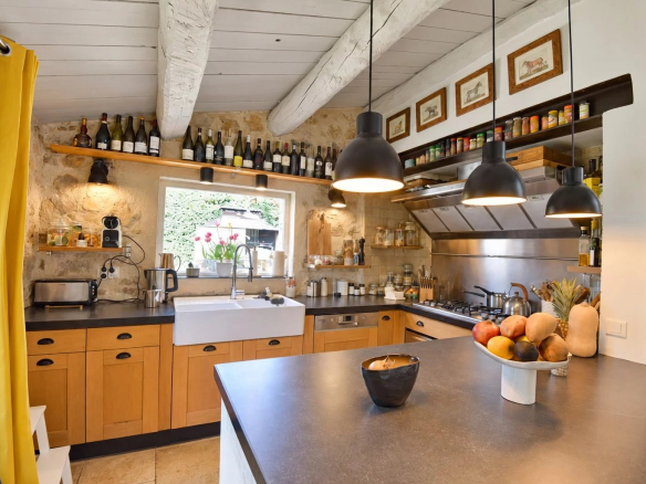 Cuisine d'une maison en pierre à Tourrettes avec plan de travail et rangement.