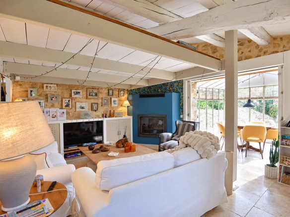 Intérieur d'une maison en pierre à Tourrettes avec un salon lumineux et des murs en pierre apparente.