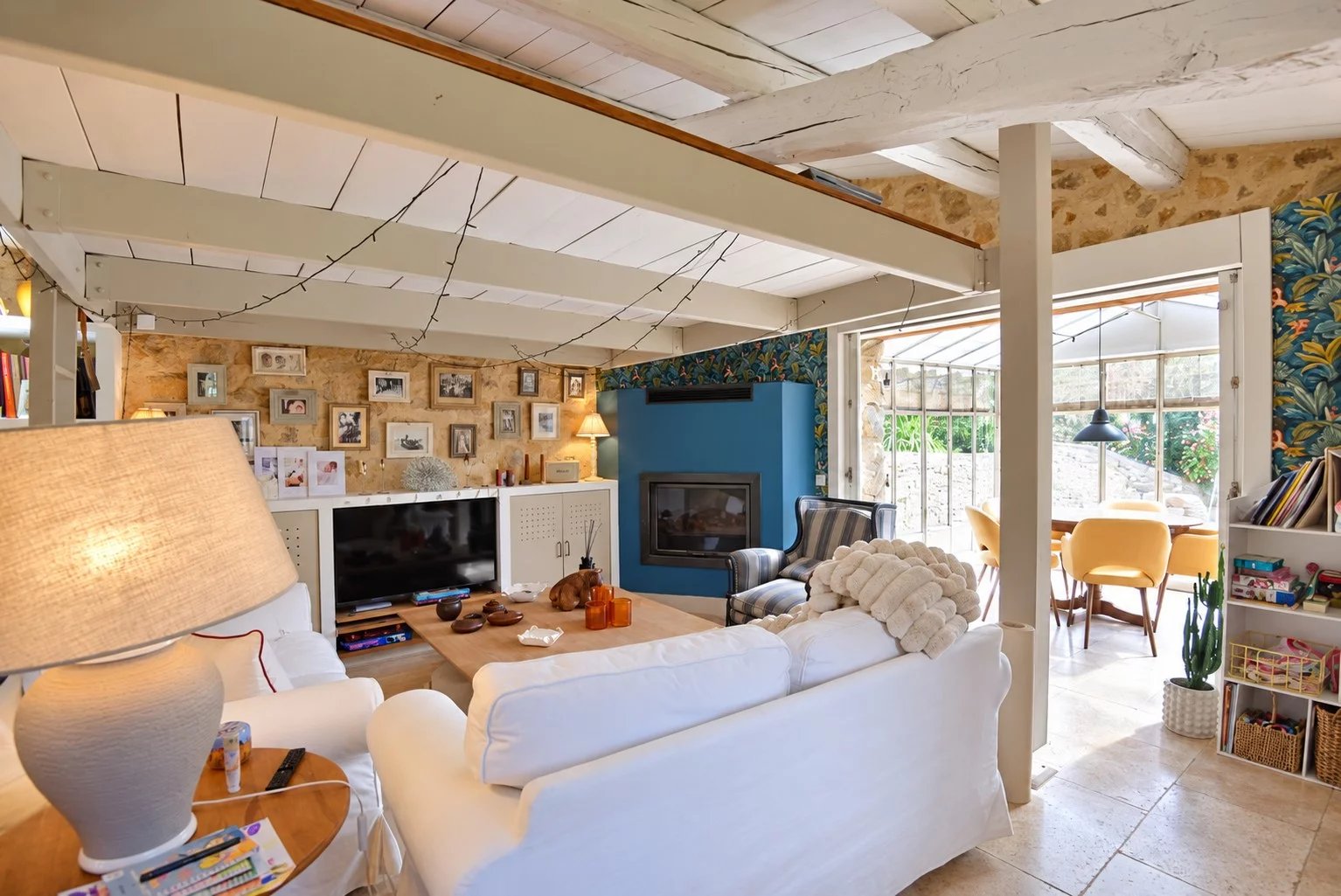 Intérieur d'une maison en pierre à Tourrettes avec un salon lumineux et des murs en pierre apparente.