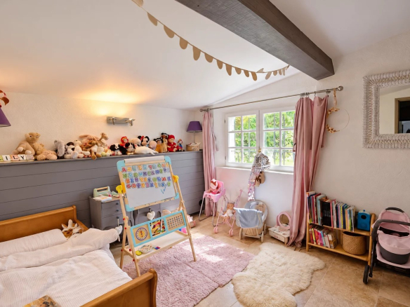 Chambre d'enfant avec lits, jouets et bibliothèque dans une maison en pierre à Tourrettes.