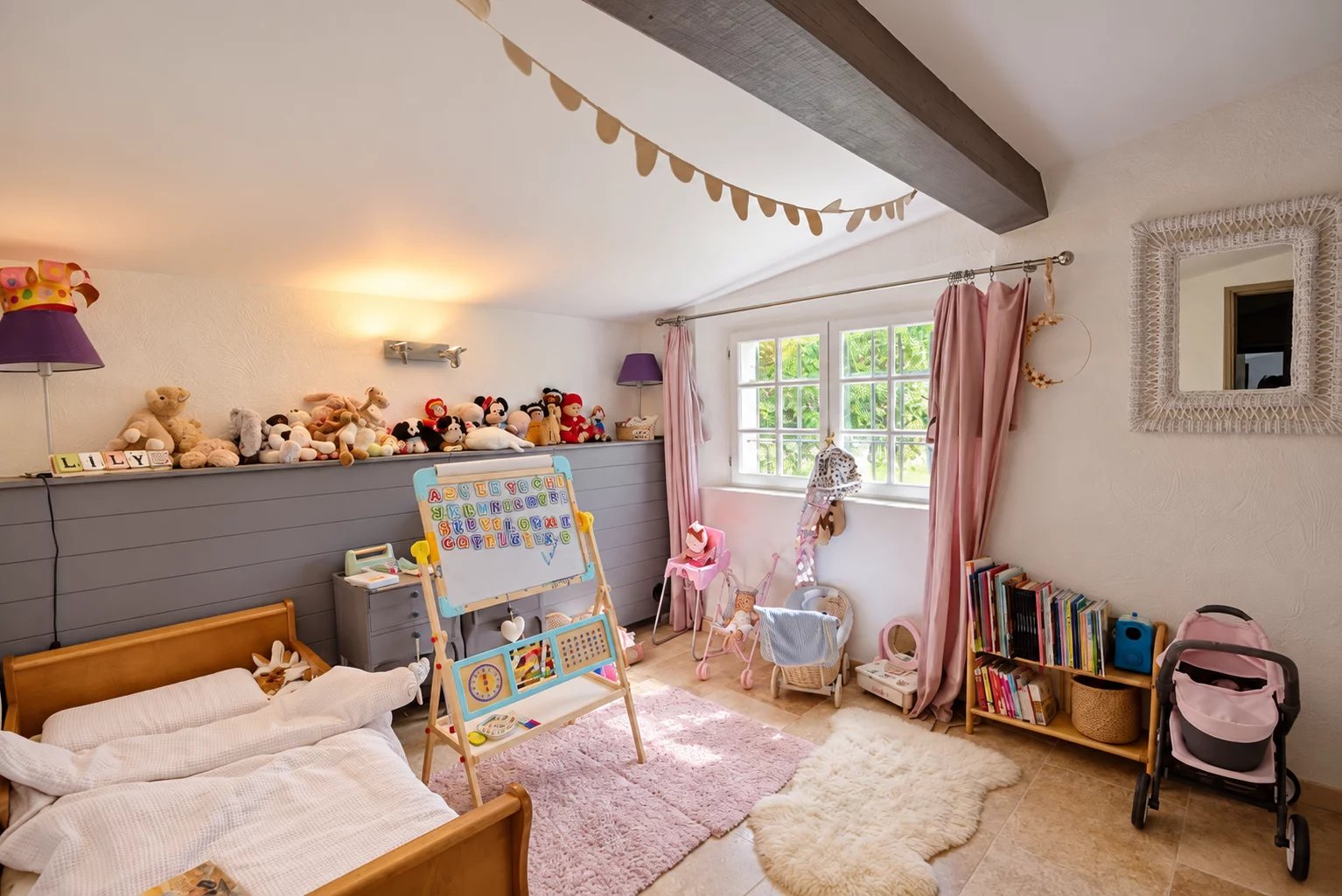 Chambre d'enfant avec lits, jouets et bibliothèque dans une maison en pierre à Tourrettes.