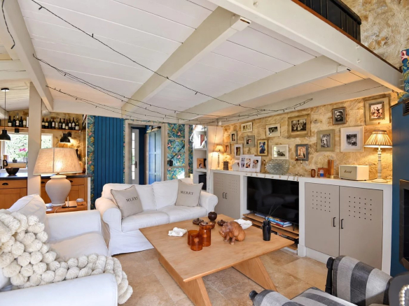 Intérieur d'une maison en pierre à Tourrettes avec salon lumineux et décoration chaleureuse.