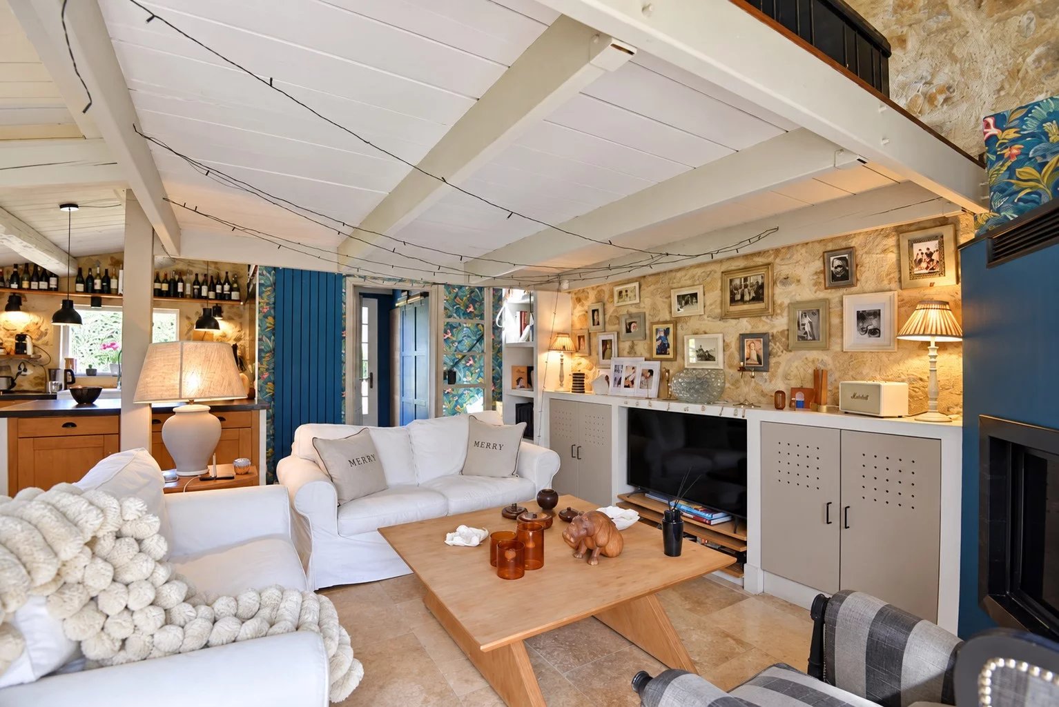 Intérieur d'une maison en pierre à Tourrettes avec salon lumineux et décoration chaleureuse.