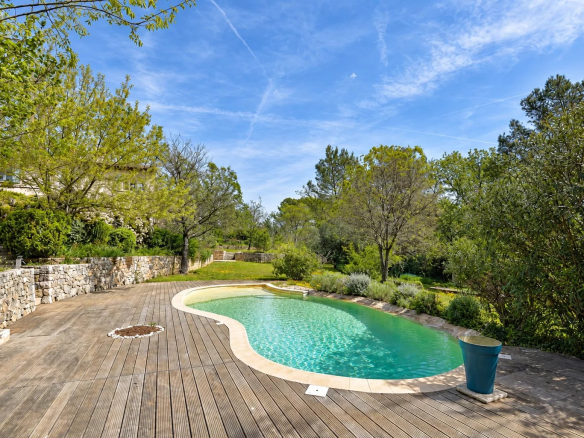Vue de la piscine entourée de verdure dans une villa provençale à Fayence.