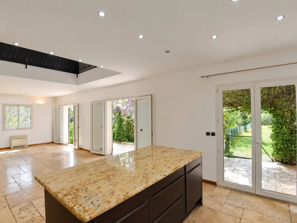 Intérieur d'une villa provençale avec cuisine ouverte et accès au jardin.