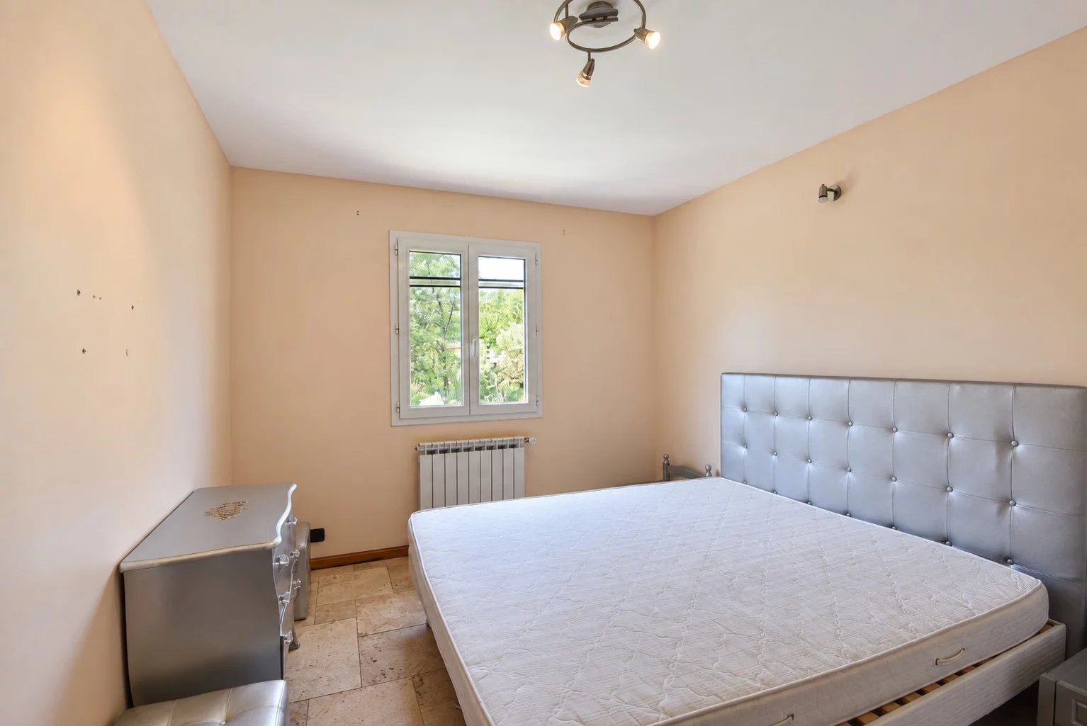 Chambre dans une villa provençale à Fayence Chambre vide avec lit et fenêtre, murs beige, dans une villa provençale à Fayence.