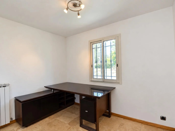 Intérieur d'un bureau avec un meuble de rangement et une fenêtre donnant sur l'extérieur.