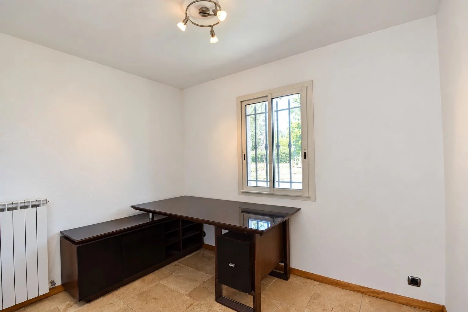 Bureau dans une villa provençale Intérieur d'un bureau avec un meuble de rangement et une fenêtre donnant sur l'extérieur.