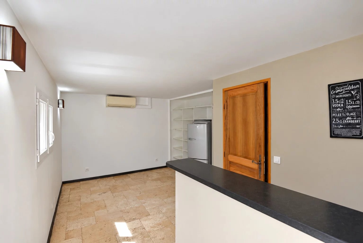 Intérieur de la villa provençale Intérieur d'une villa provençale avec un bar et un réfrigérateur, murs clairs et espace ouvert.