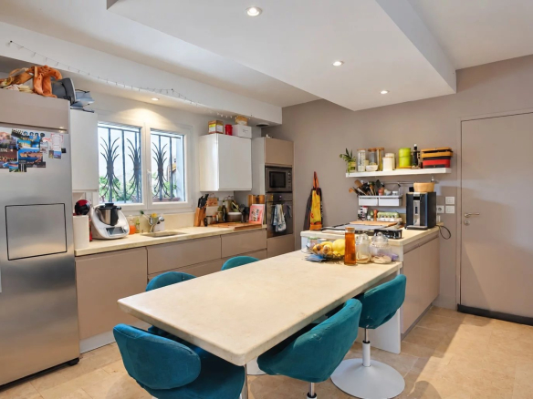 Cuisine moderne avec îlot central et équipements, dans une villa à Saint-Paul-en-Forêt.