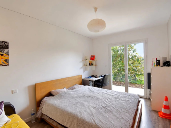 Chambre d'une villa à Saint-Paul-en-Forêt avec lit double et accès à l'extérieur.