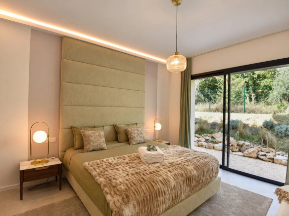 Chambre d'une villa contemporaine à Tourrettes avec lit double et accès au jardin.