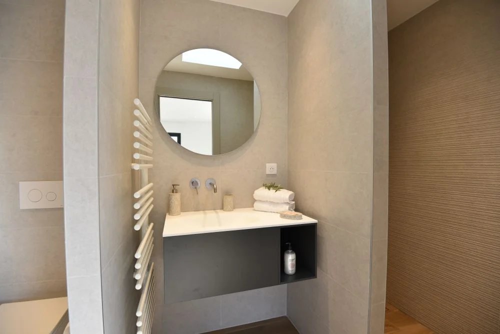Salle de bain contemporaine Salle de bain moderne avec miroir rond et lavabo dans une villa contemporaine.