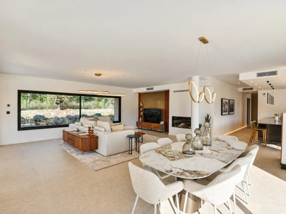 Intérieur d'une villa contemporaine avec salon et salle à manger, grandes baies vitrées et décoration moderne.