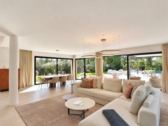 Intérieur d'une villa contemporaine à Tourrettes avec salon, salle à manger et vue sur la piscine.