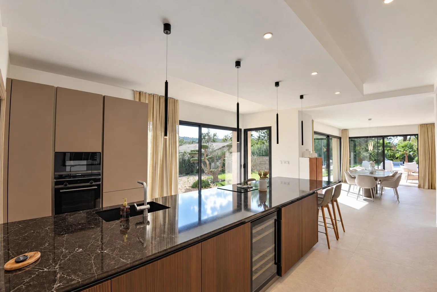 Cuisine de villa contemporaine à Tourrettes Cuisine moderne avec îlot central dans une villa contemporaine à Tourrettes, vue sur le jardin.