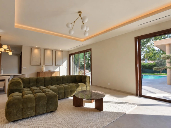 Intérieur d'une villa contemporaine avec un salon et une vue sur la piscine.