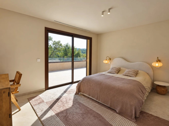 Chambre d'une villa moderne avec lit double et accès à une terrasse, à Tourrettes.