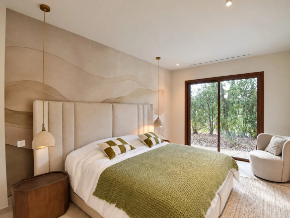 Chambre d'une villa contemporaine avec lit double et vue sur le jardin.