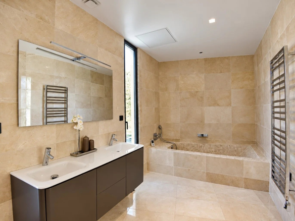 Salle de bain moderne avec baignoire et double vasque en marbre beige