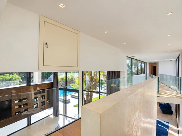 Intérieur d'une villa contemporaine à Fayence avec balustrade en verre et vue sur le jardin.