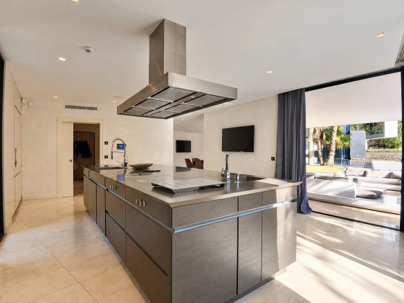 Cuisine moderne d'une villa contemporaine à Fayence avec îlot central et grandes ouvertures sur l'extérieur.