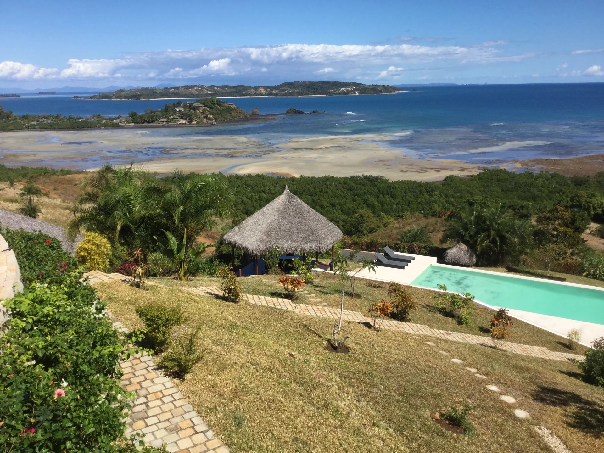 Villa avec vue océan à Nosy Be Vue de la villa avec piscine et jardin tropical surplombant l'océan à Nosy Be, Madagascar.